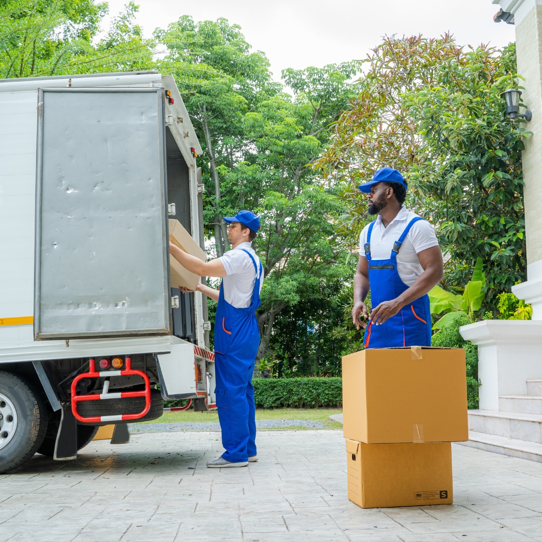 Two international movers in Dubai, UAE, loading boxes into a truck, ready to assist with your relocation.